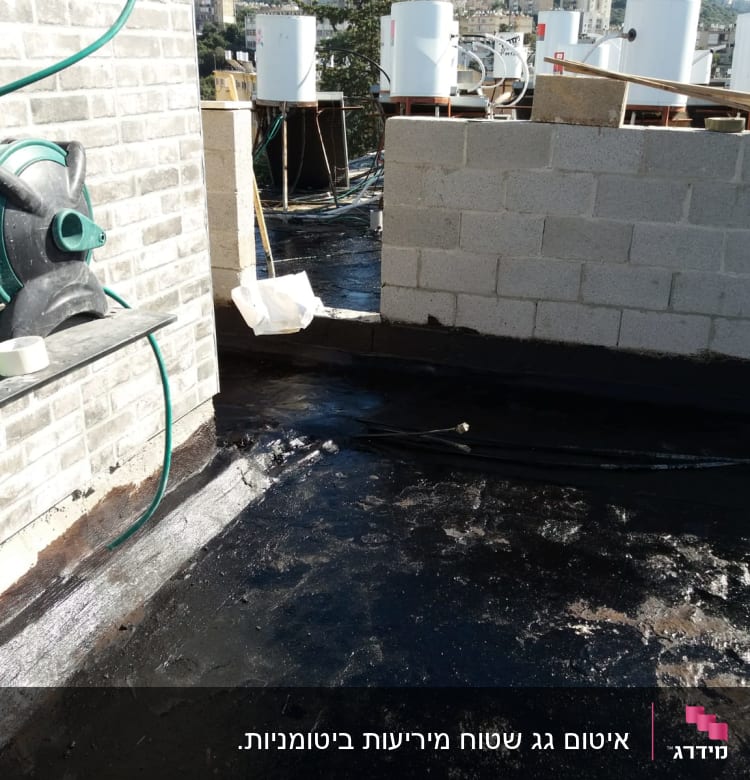 גג אטום בזפת עם צינורות ומיכלים